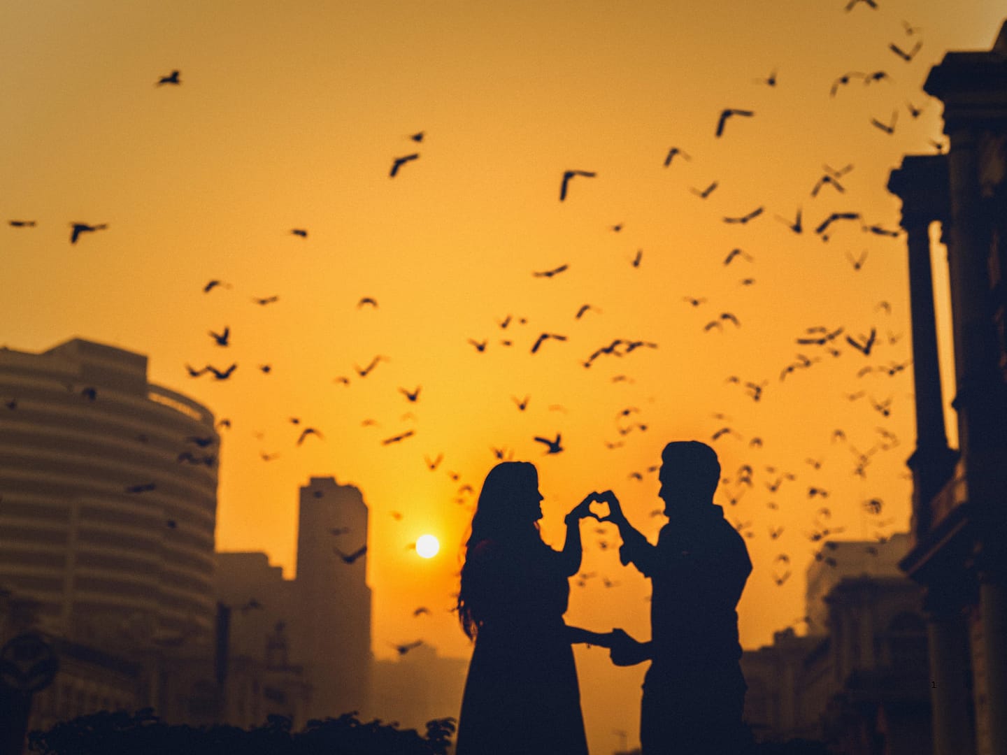 Romantic silhouette of a couple forming a heart at sunset - how to make him desire you