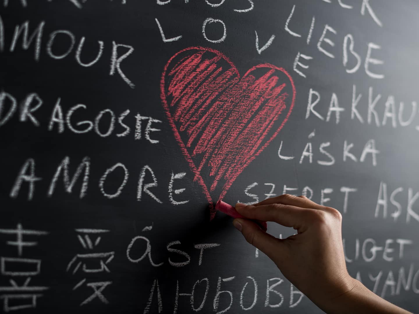 Hand drawing love icon with red crayon on a black board