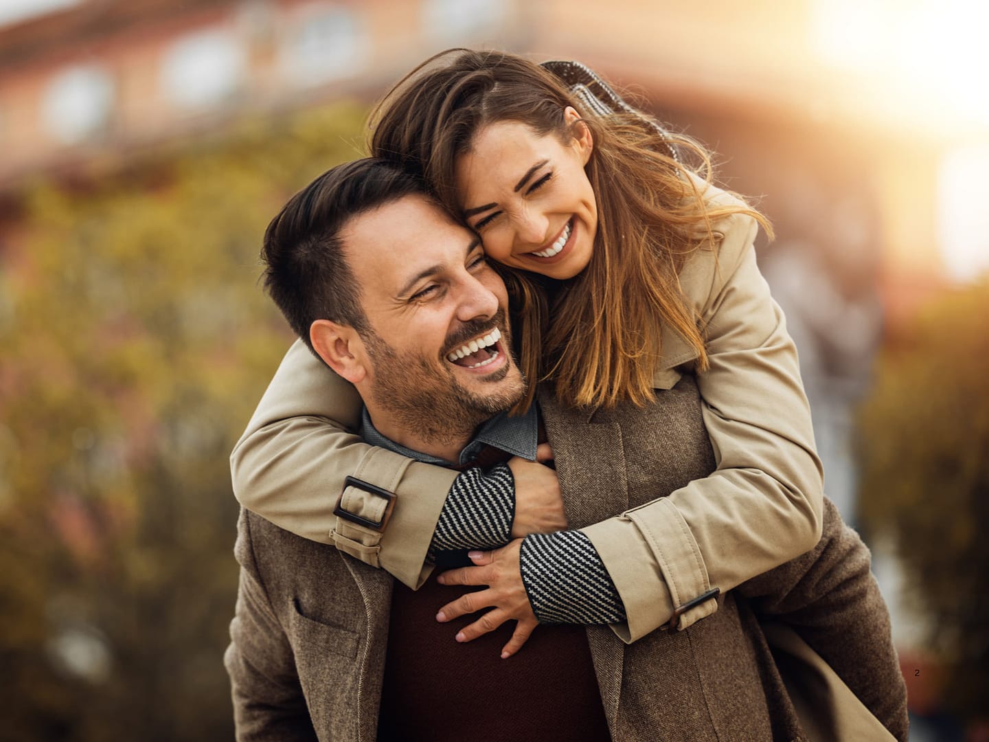 Woman piggyback on a man's back. The happy couple both smiling and laughing