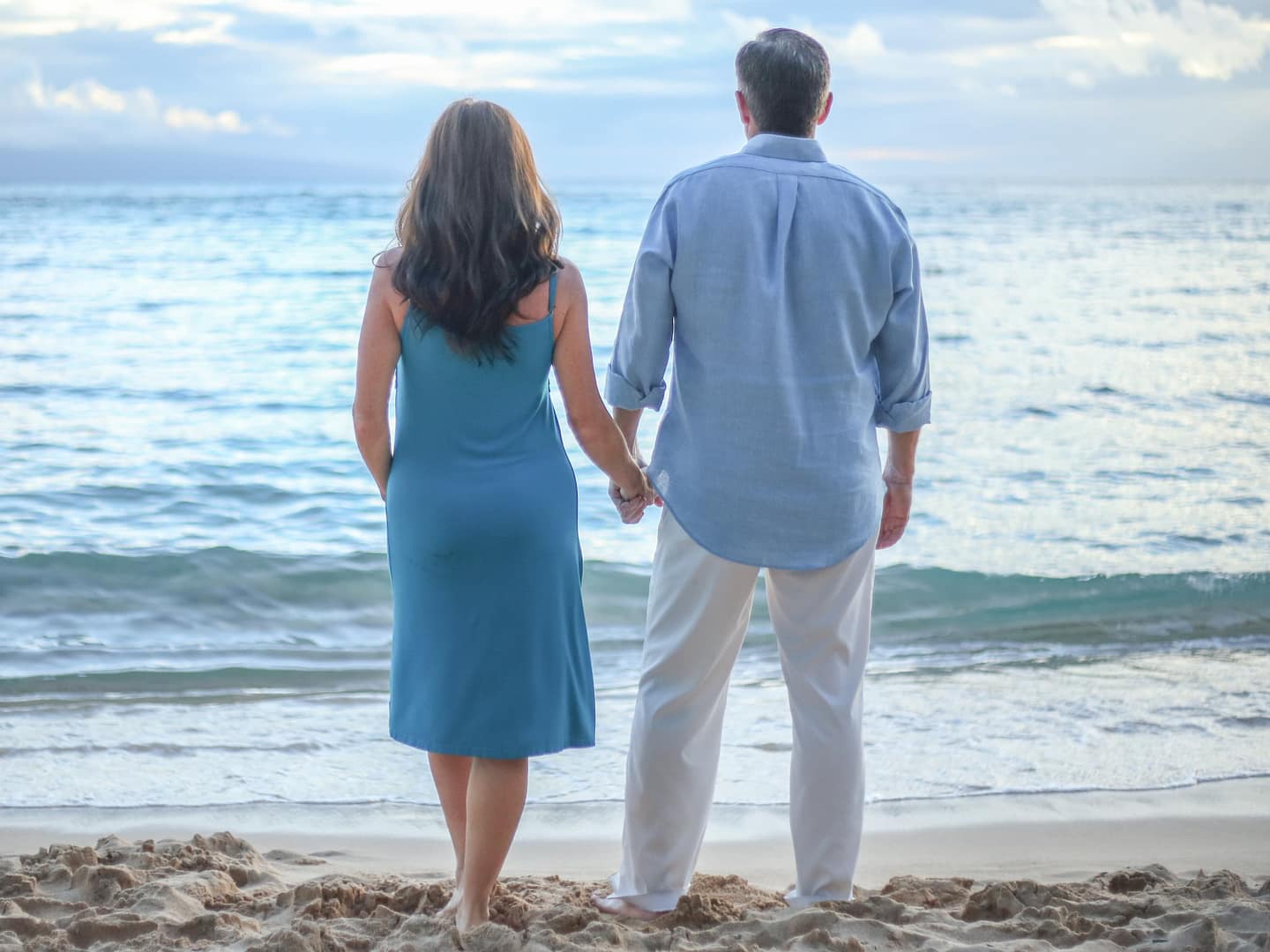 Man and woman holding each other's hand while looking at the beach - how to rebuild your marriage