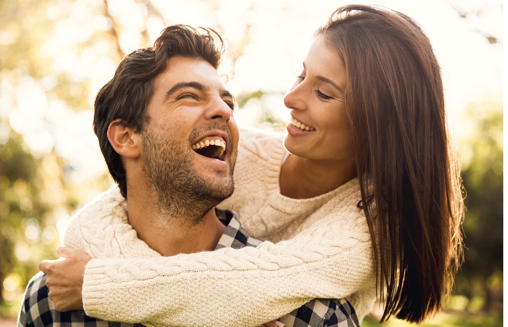 Happy couple who started as best friends laughing together outdoors representing friendship to forever love story