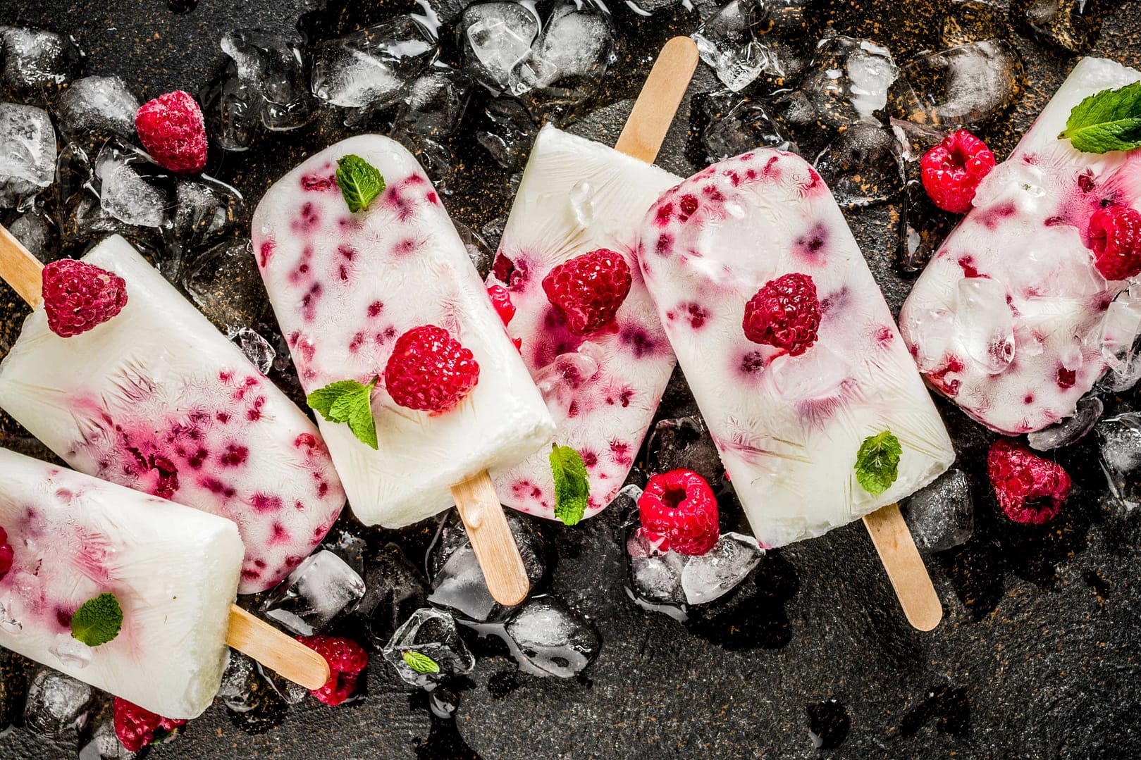 Summer sweet desserts, homemade organic ice cream popsicles from raspberry and yogurt, dark rusty background
