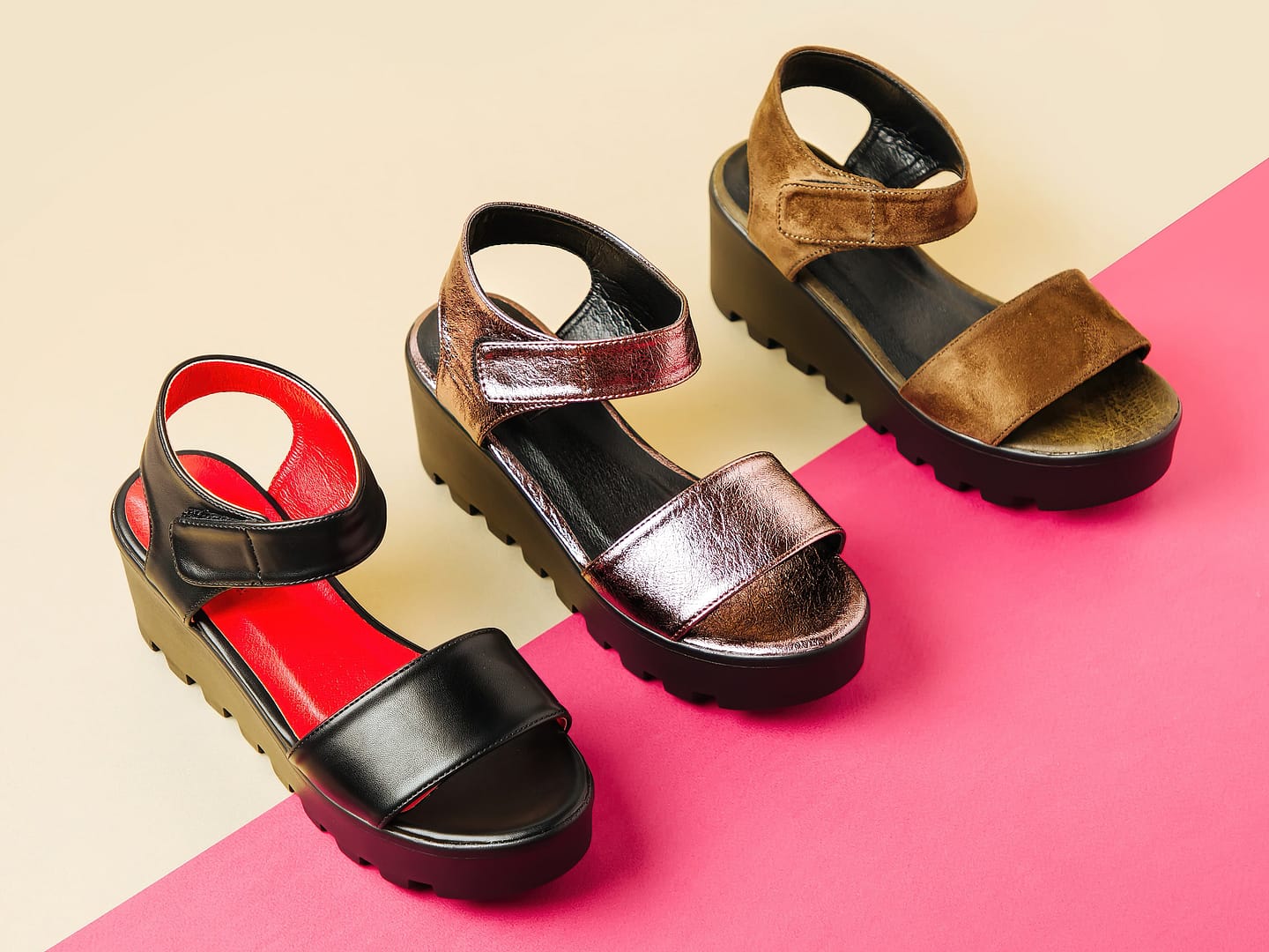 Three pairs of summer platform sandals on a two-tone background. The sandals are black with a red insole, metallic bronze, and brown suede. Each pair features a thick sole and an ankle strap, perfect for sunny days