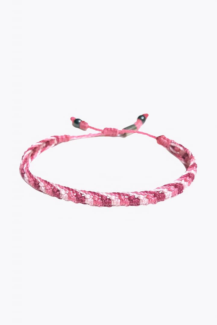 A pink braided bracelet with a black clasp