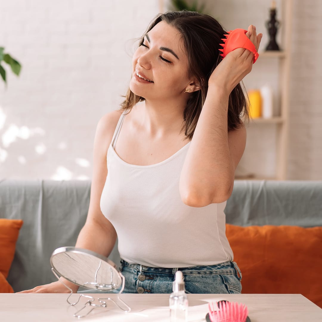 Lady enjoys giving herself a head massage with a scalp massager