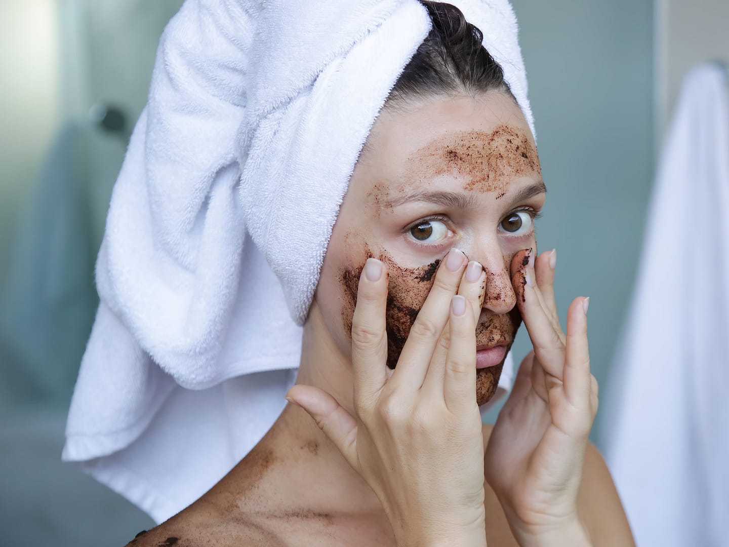 Portrait of young woman with coffee scrub on her face