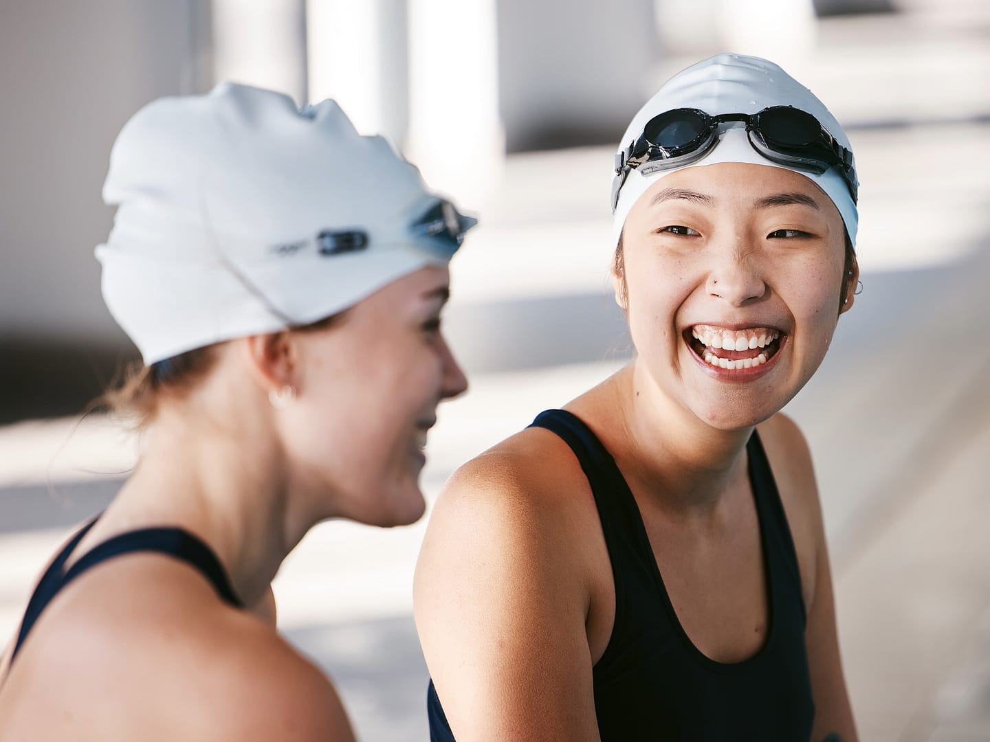 Female swimmers laughing and having fun during training in the swimming pool