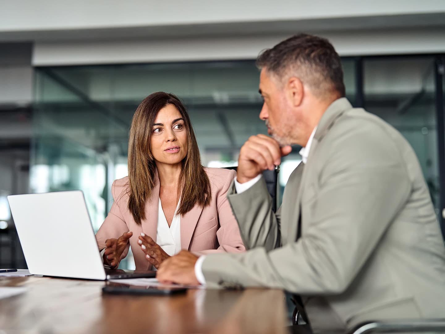 Busy colleagues executives using laptop discussing digital project commercial tech solution at meeting table