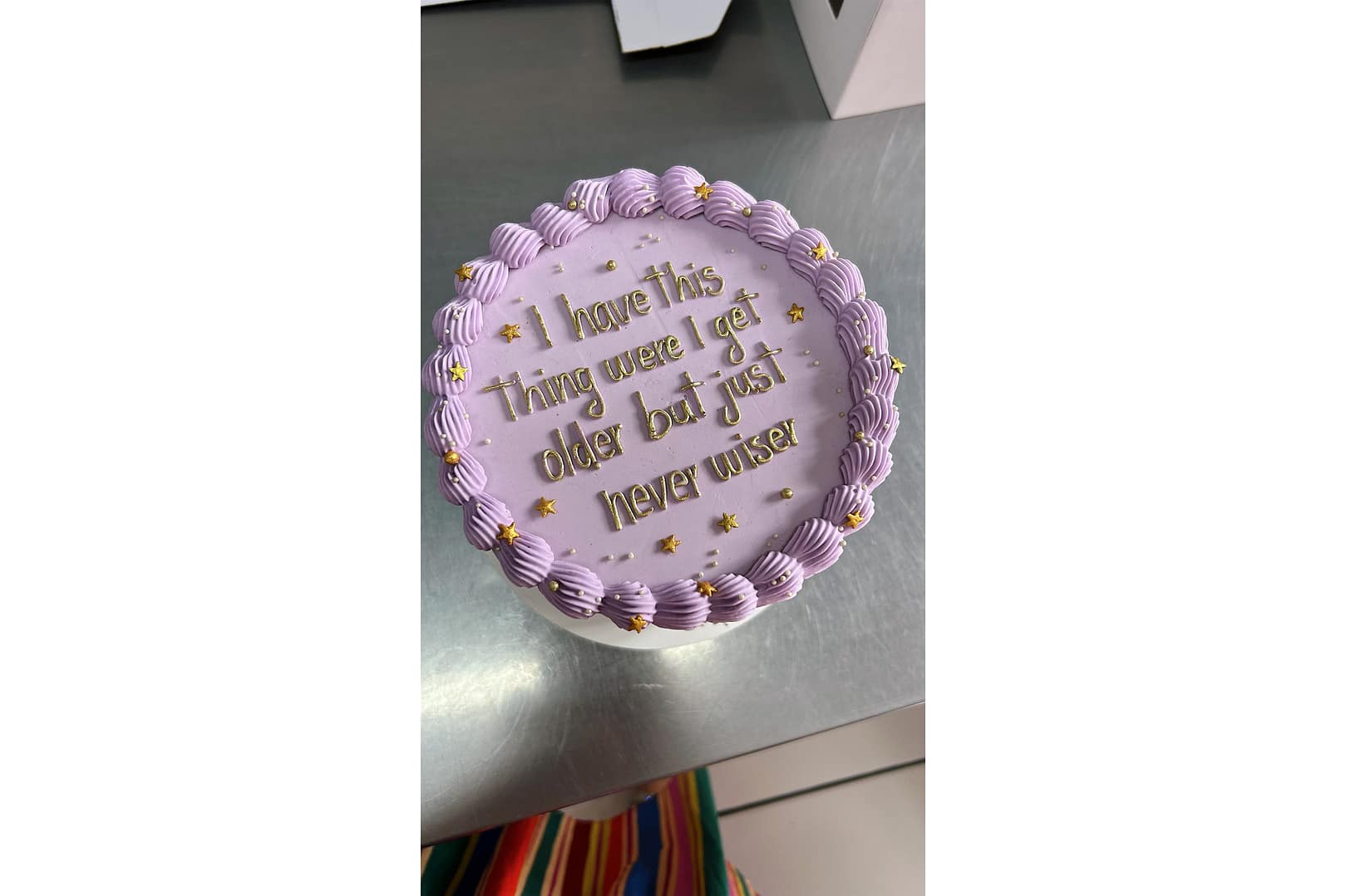 A purple cake with a piped border and star decorations reads, "I have this thing where I get older but just never wiser." It's the perfect birthday wish for a best friend who embraces life's playful side