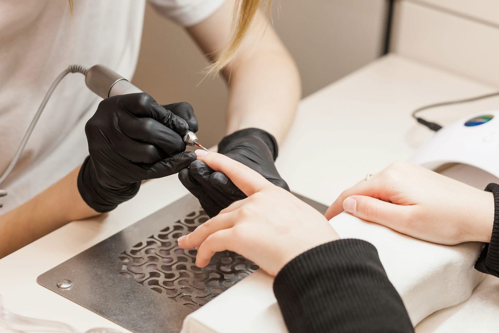 Close-up of the hands of a master and the hands of a manicure client