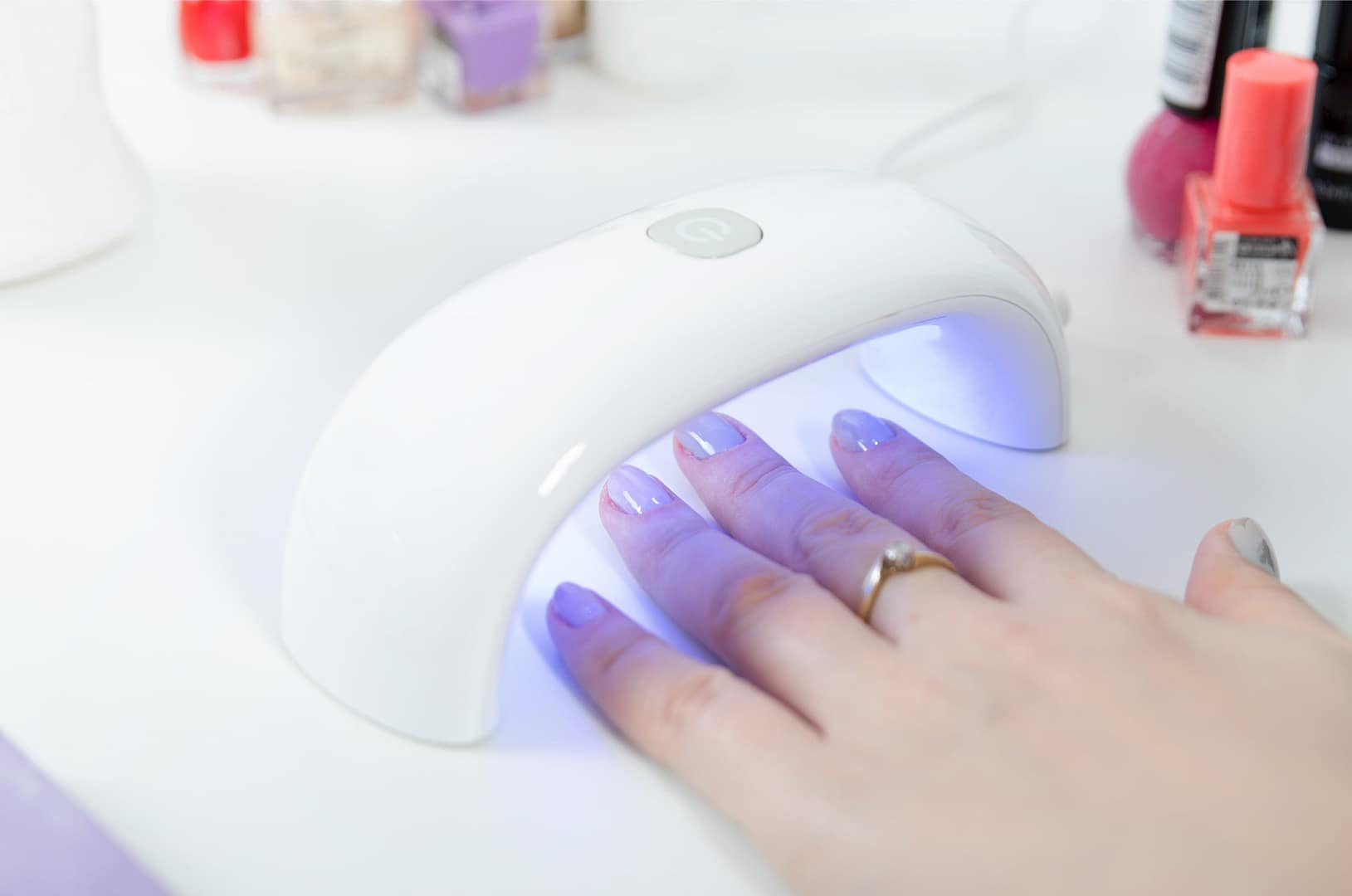 Hand with nail polish using UV lamp nail dryer