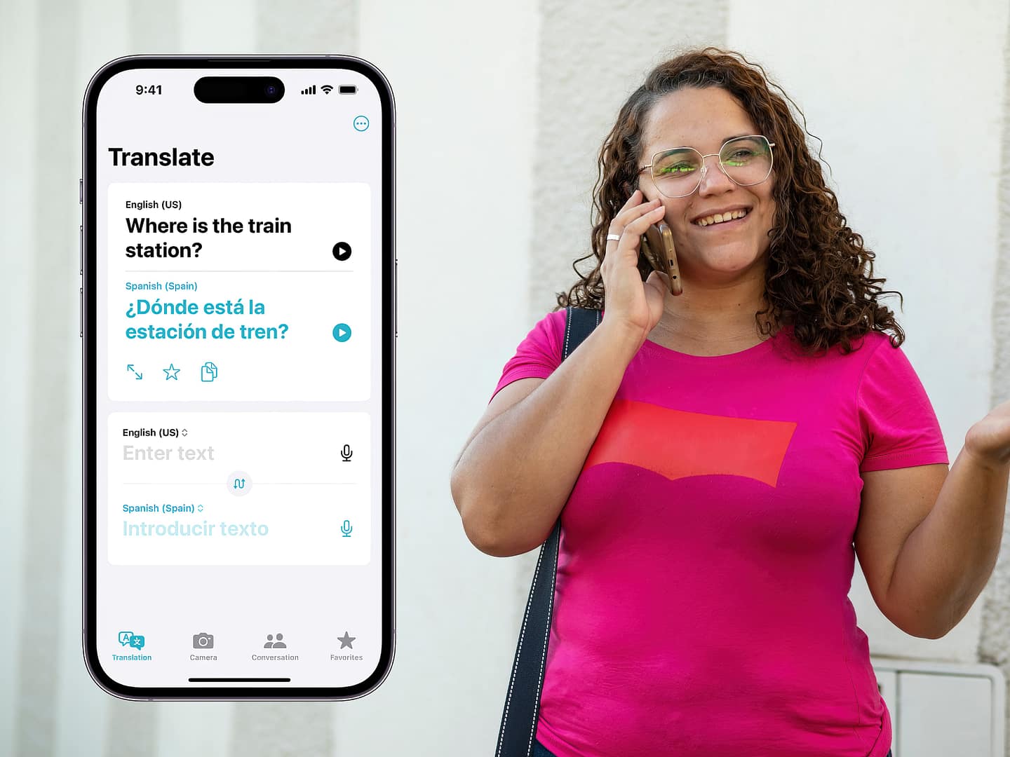 Asking a latina woman in pink shirt in English to Spanish, where the train station is via Apple's iOS default 'Translate' app on an iPhone that has Dynamic Island on it
