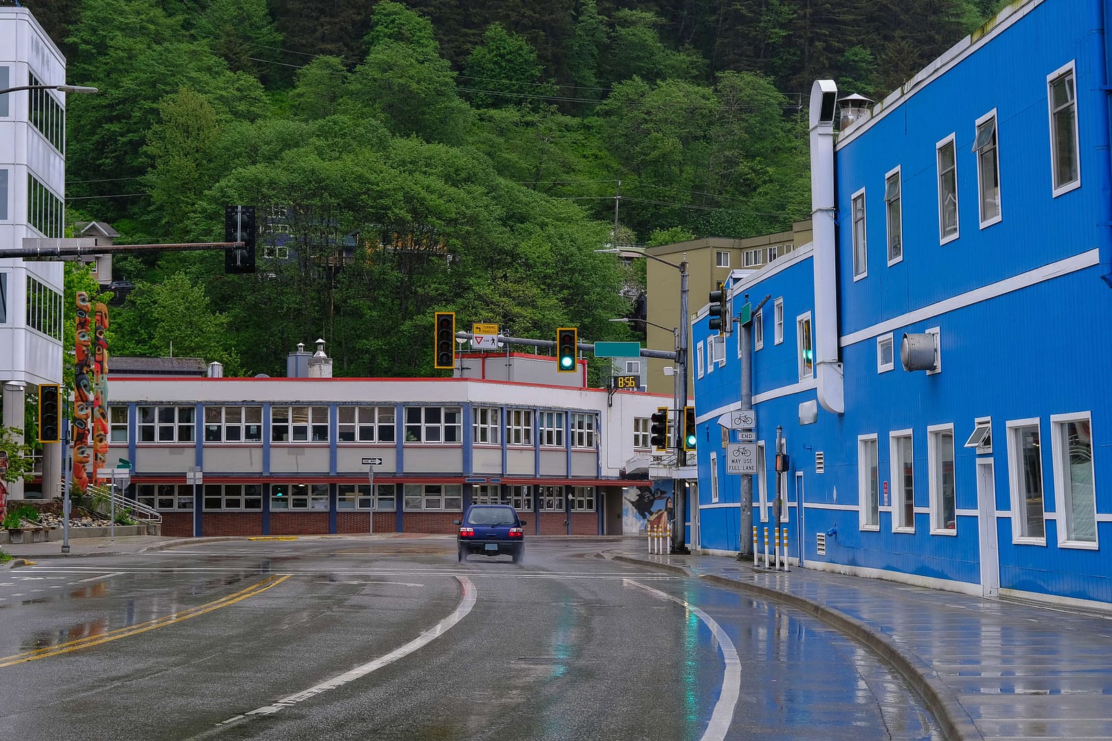 Street view cityscape town landscape nature scenery in Juneau, Alaska with historic wood house facades, gravel roads, lush vegetation, birds and private homes in old town downtown skyline