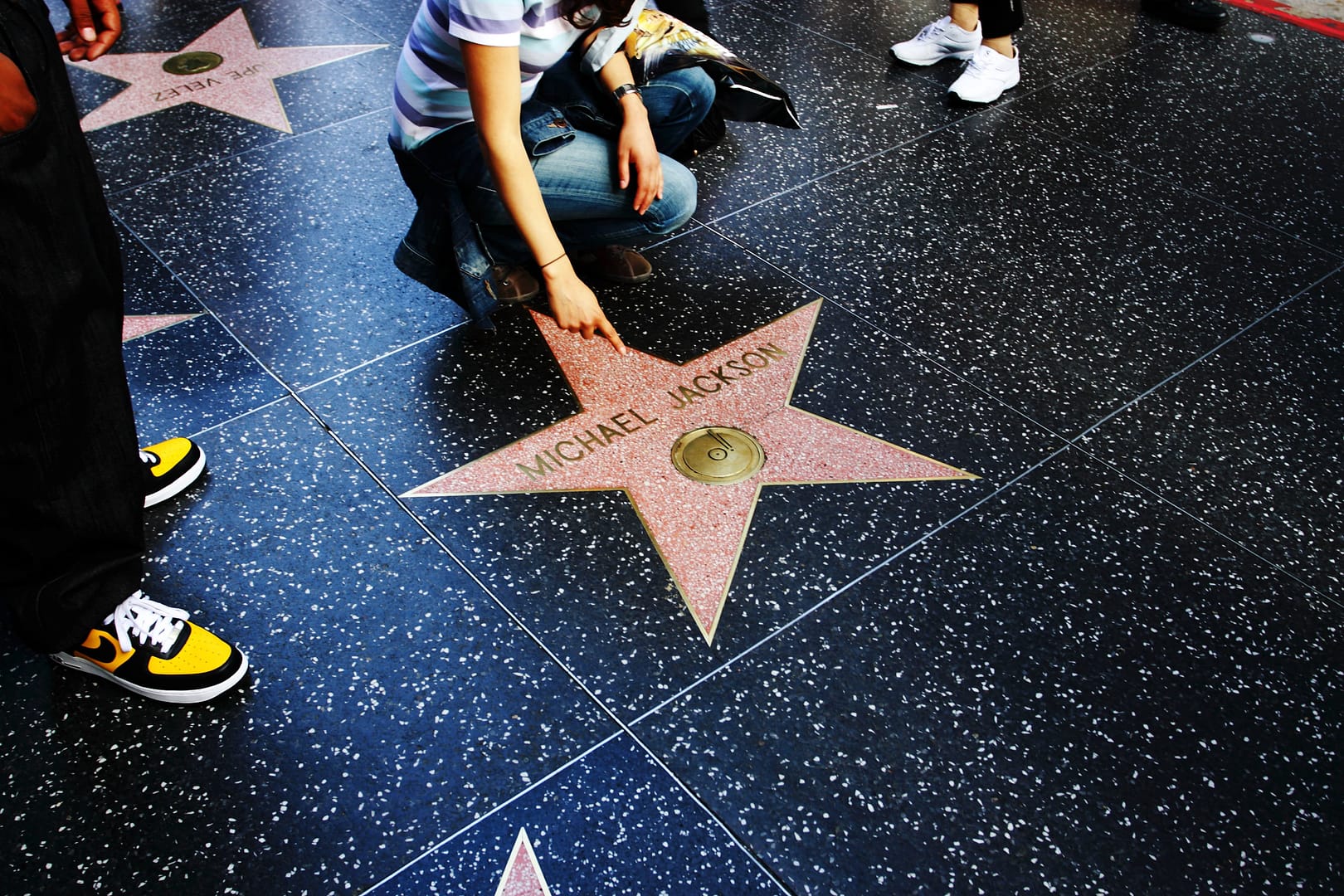 A kid pointing at Michael Jackson's star at Hollywood Walk of Fame