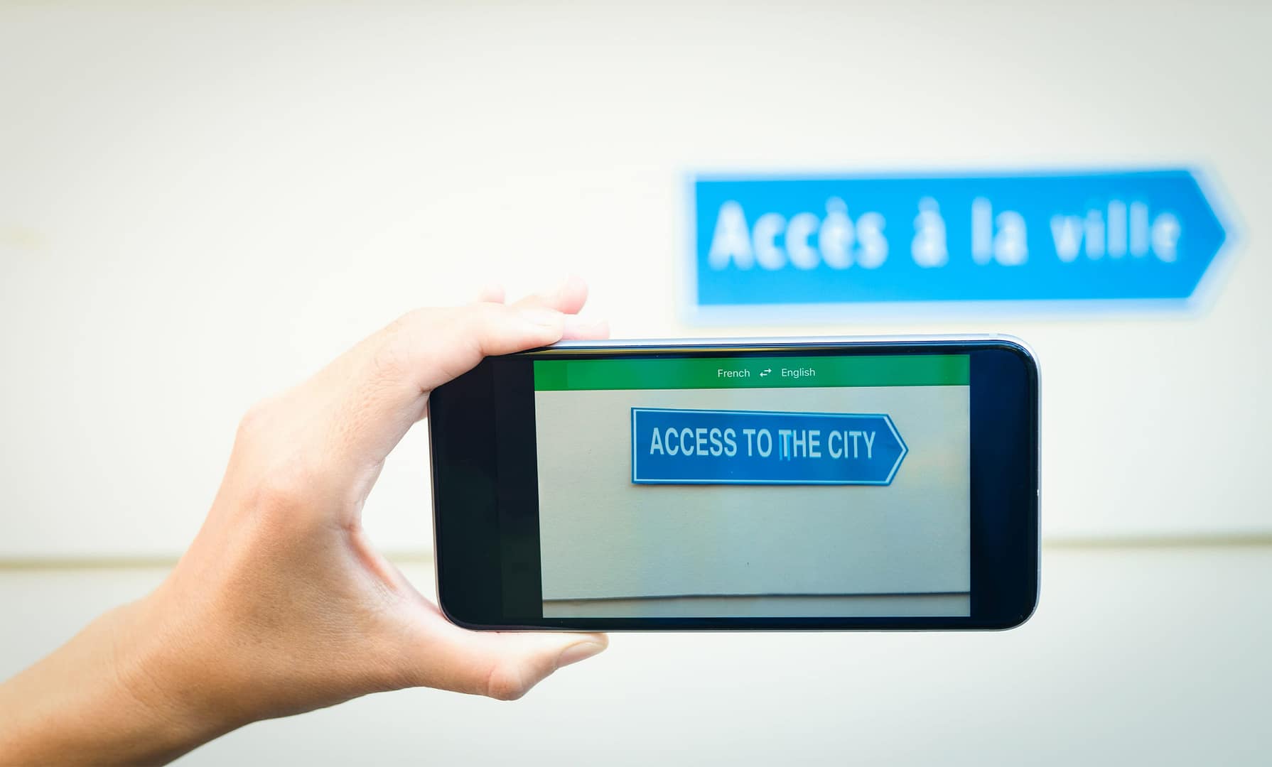 A person capturing a photo of a sign using a smartphone