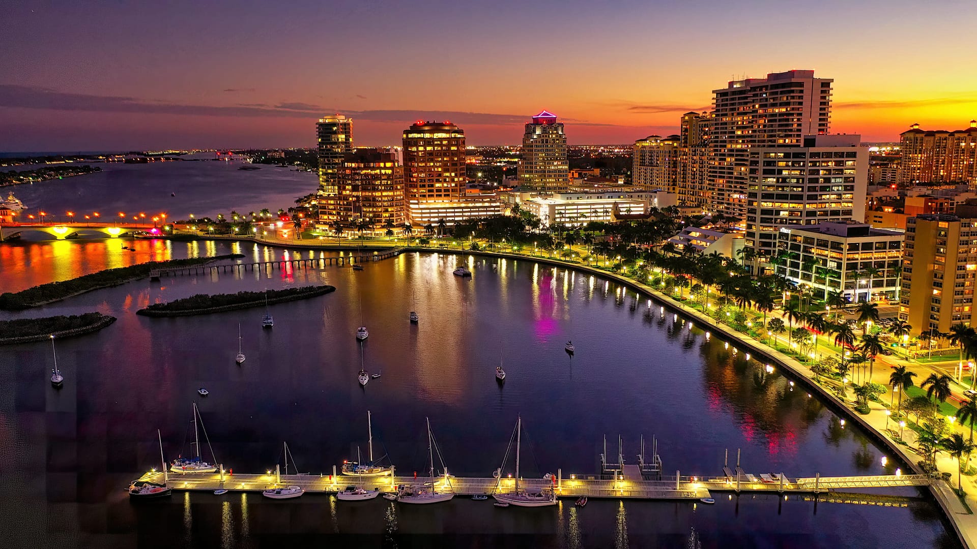 A vibrant city skyline at dusk, adorned with boats and towering buildings, creating a picturesque scene