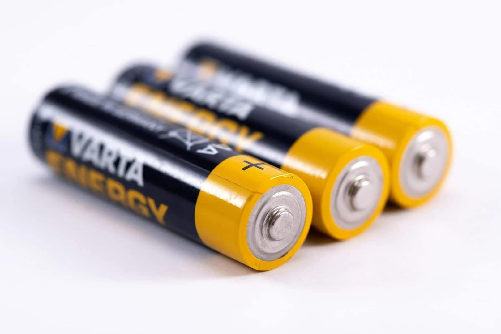 Three batteries are displayed on a plain white surface, with their labels facing upwards