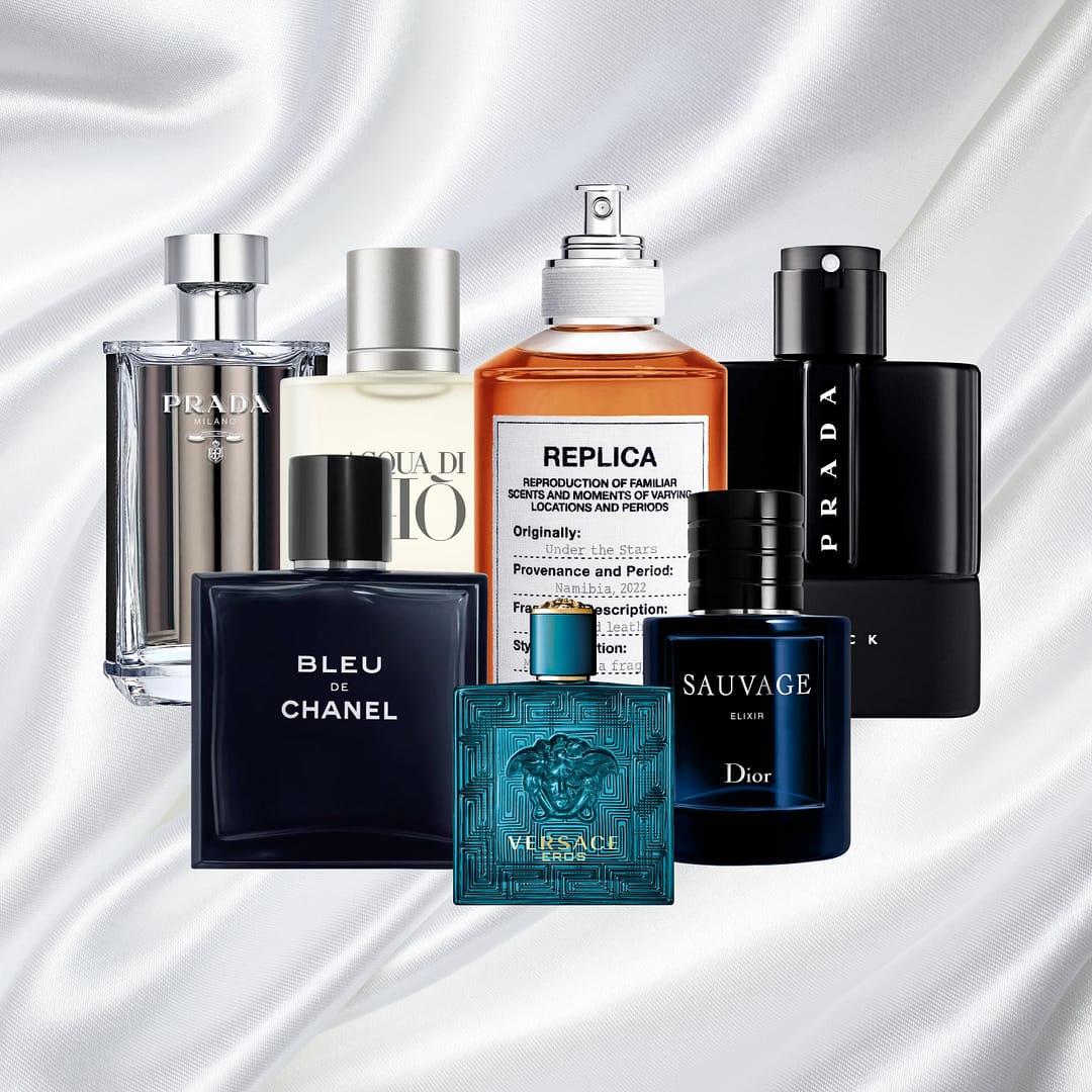 Seven bottles of the Best Colognes for Men, featuring brands like Chanel, Dior, Versace, Prada, and Maison Margiela, are elegantly arranged on a white satin fabric background