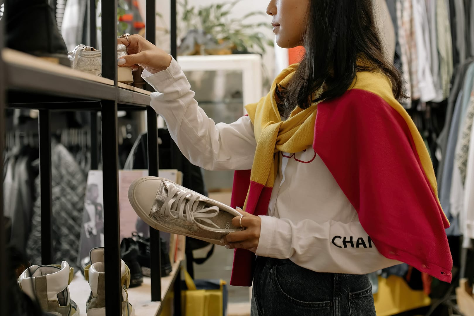 Women arrange shoes in a rack