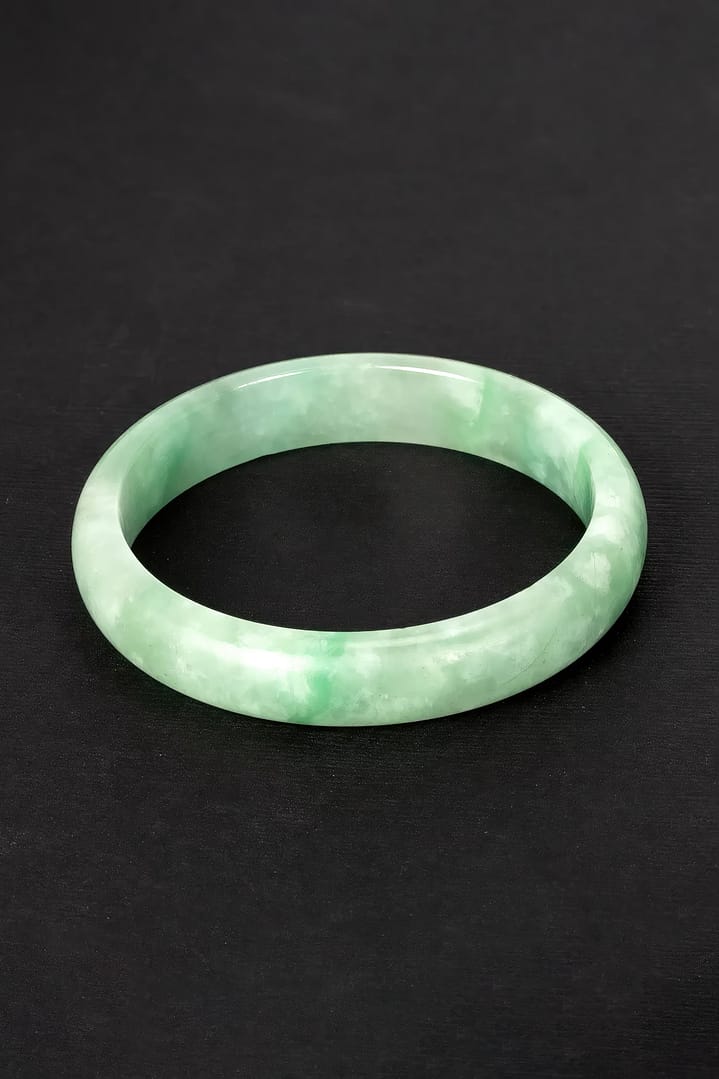 Green jade bangle bracelet on a black background