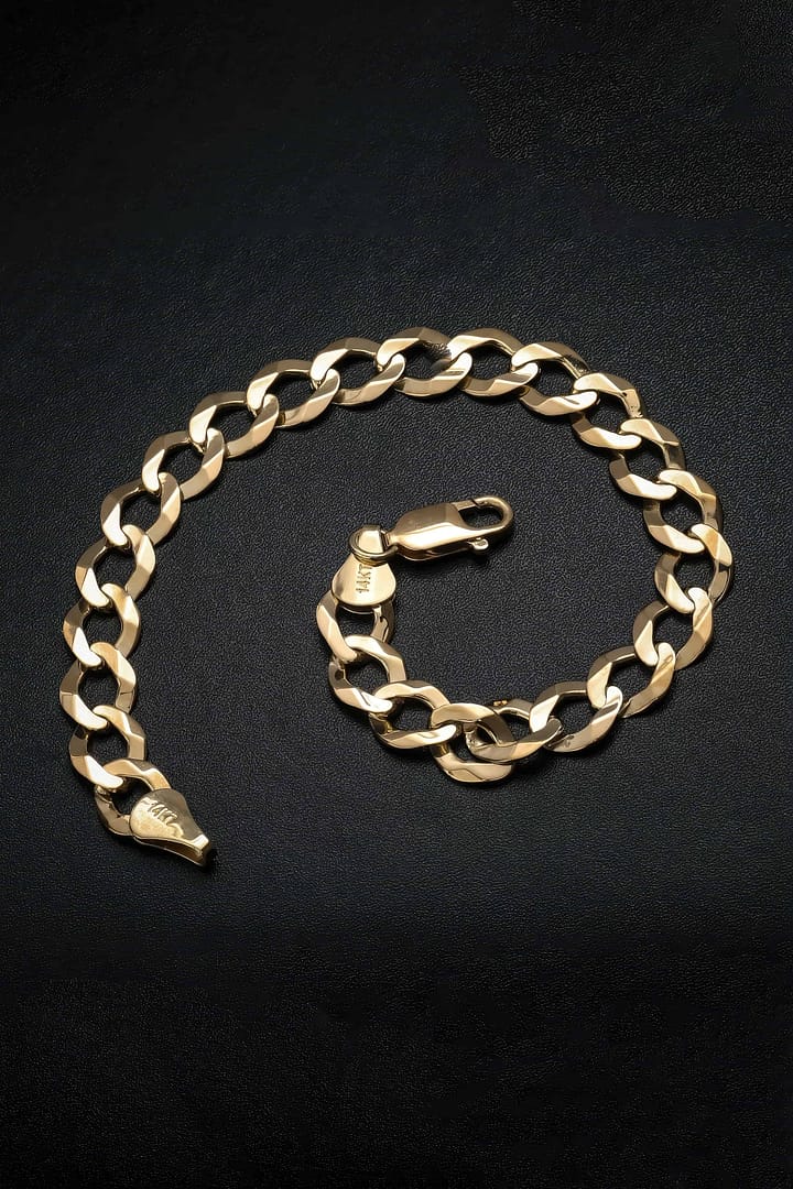 Gold chain link bracelet, isolated against a black background