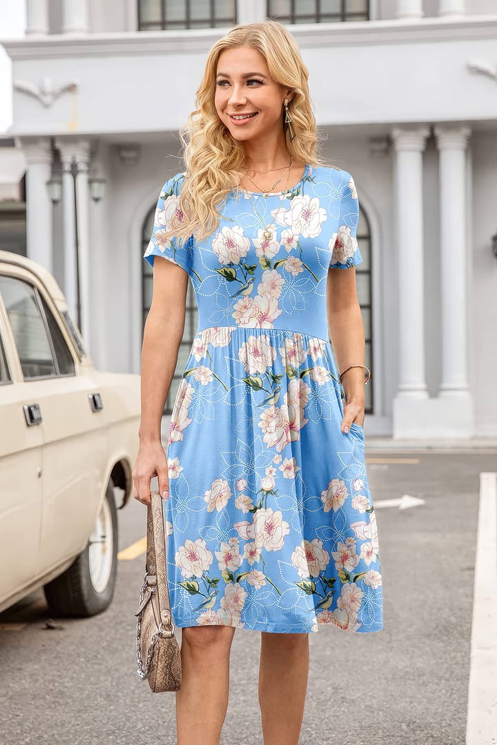 A stylish woman wearing a blue floral dress gracefully strolling along a bustling city street