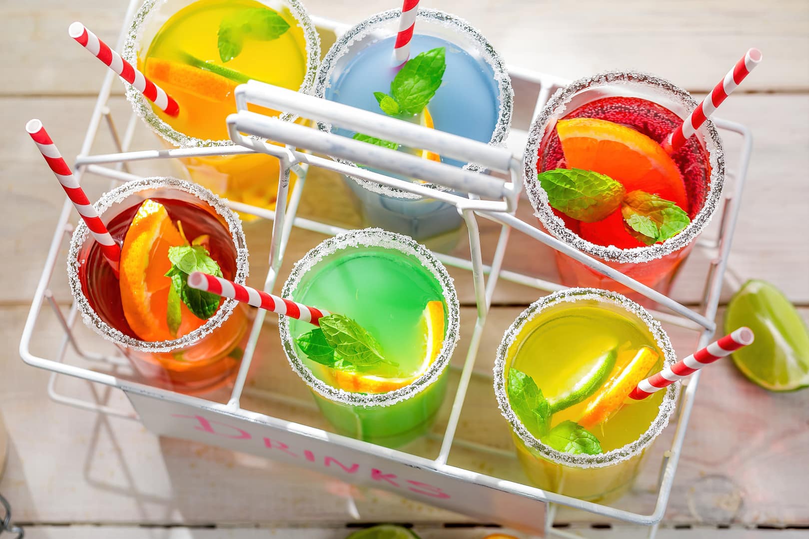 Six glasses of different lemonade drinks with citrus fruits