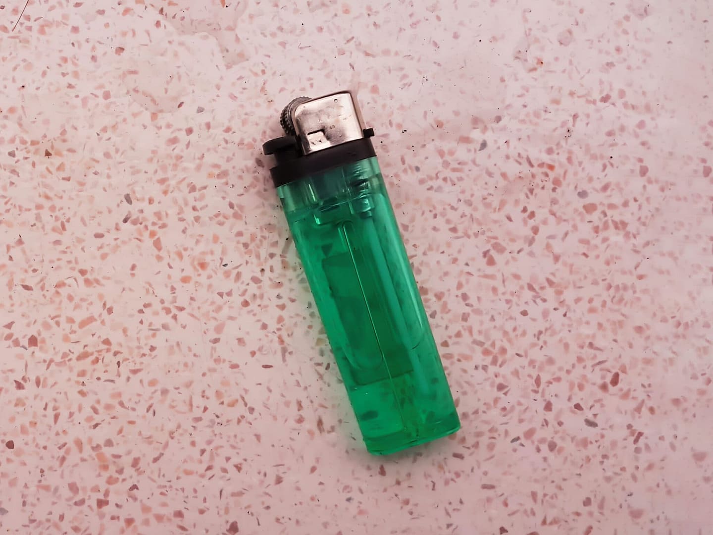A green lighter placed on a wooden table