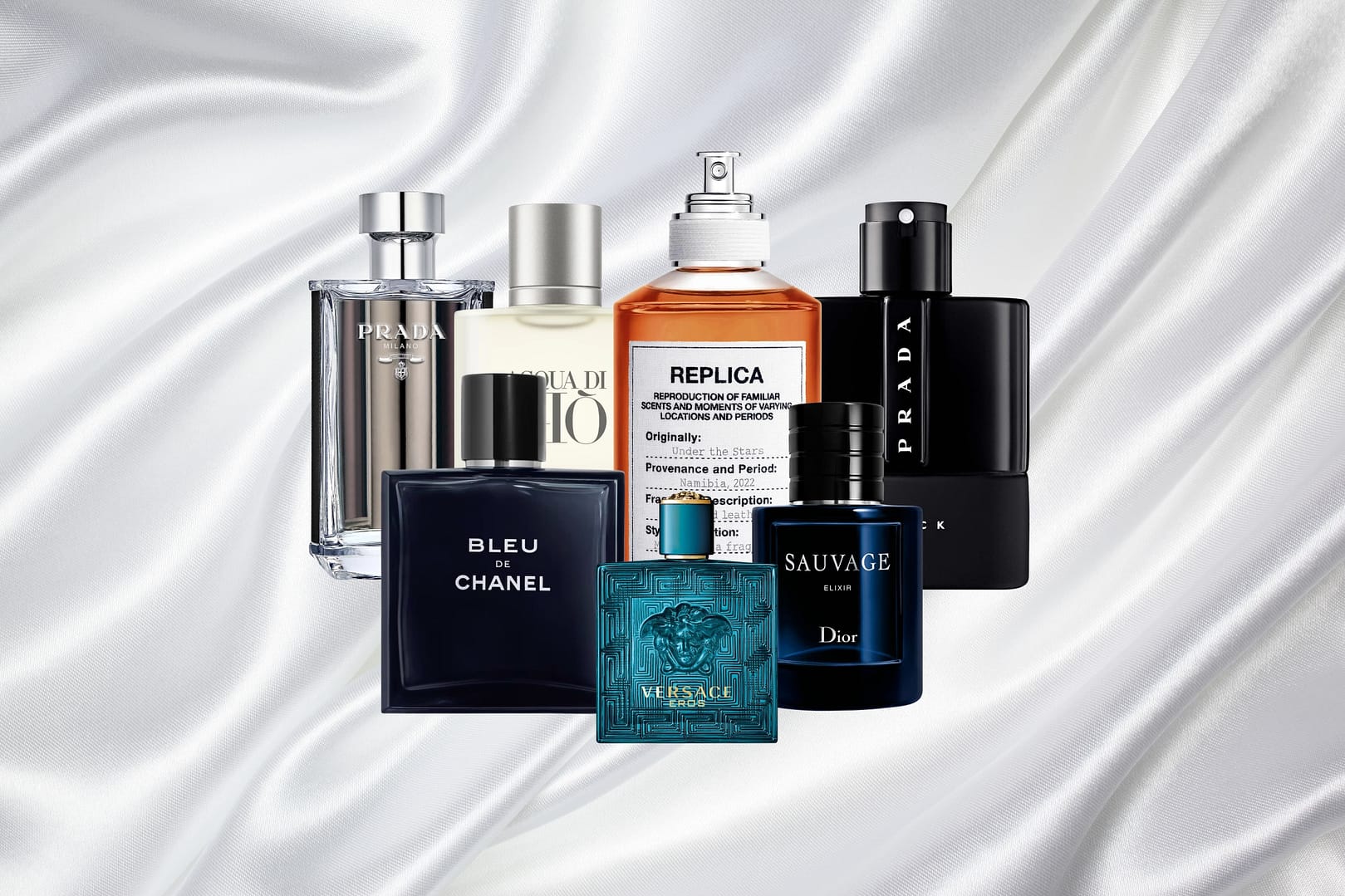 Seven bottles of the Best Colognes for Men, featuring brands like Chanel, Dior, Versace, Prada, and Maison Margiela, are elegantly arranged on a white satin fabric background