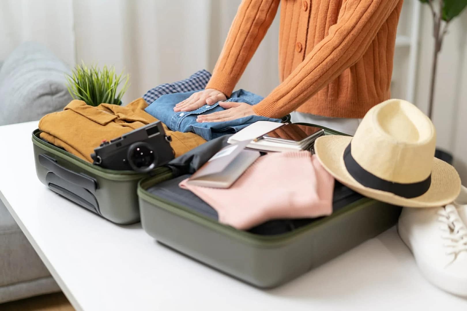 Woman check clothes into luggage in suitcase checklist before holidays trip