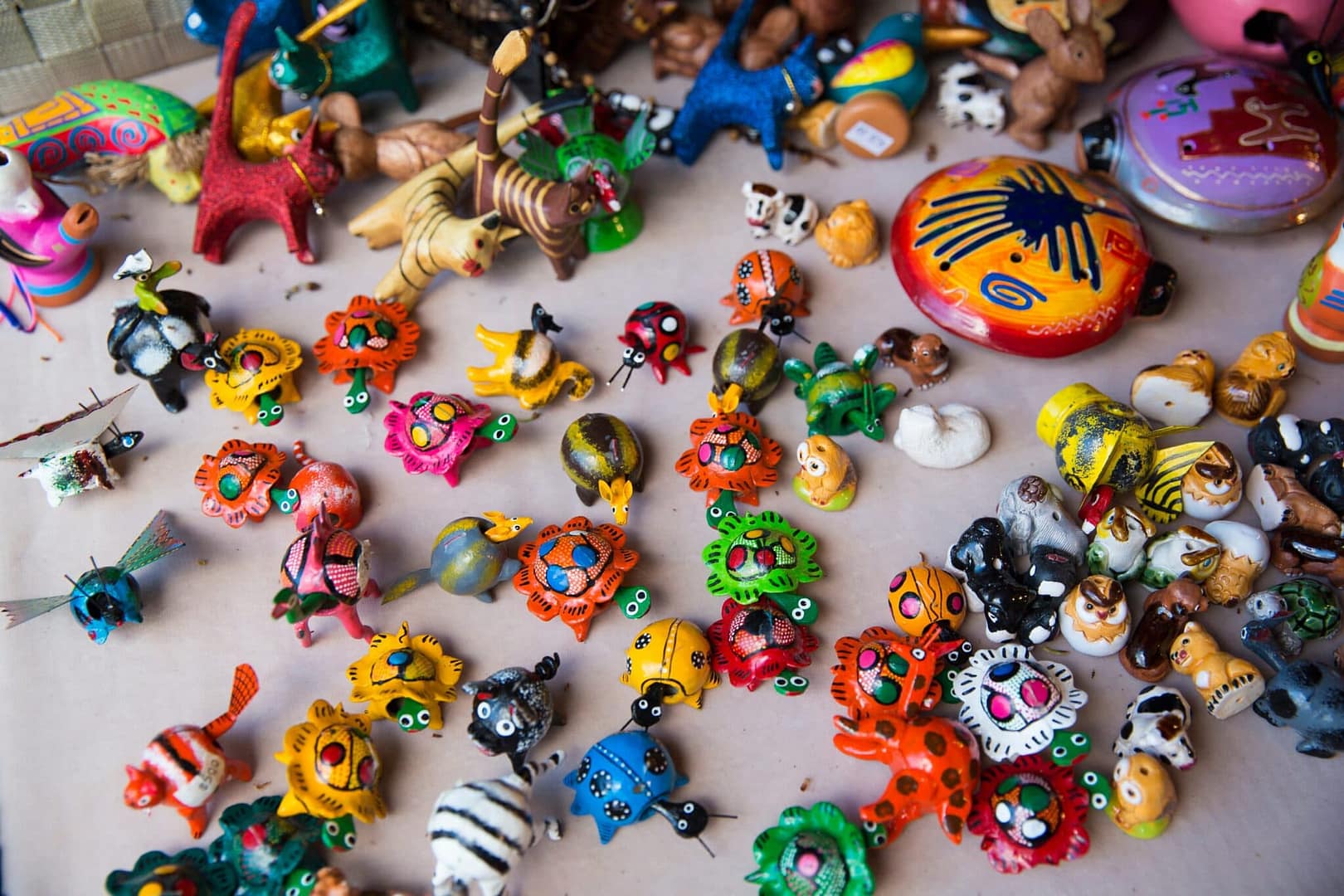 Close-up a table filled with various toys, including dolls, and stuffed animals